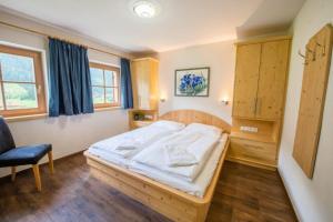a bedroom with a bed and a chair in it at Schöneben Chalet MiJoBa in Wald im Pinzgau +31 photos