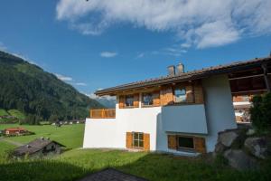 a building on a hill with a green field at Schöneben Chalet MiJoBa in Wald im Pinzgau