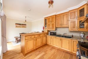 a kitchen with wooden cabinets and a wooden floor at Beautiful 5-Bed Villa in Waterford in Waterford