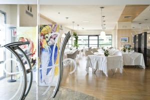 a dining room with white tables and white chairs at Grand Hotel Garden in Barile