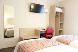 a hotel room with two beds and a desk and a tv at Brit Hotel Brive La Gaillarde - Restaurant La Limousine in Malemort-sur-Corrèze