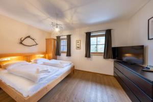 ein Schlafzimmer mit einem Bett und einem Flachbildfernseher in der Unterkunft Schöneben Chalet Edelhirsch in Wald im Pinzgau + 38 Fotos