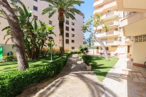 a walkway in the courtyard of a building with palm trees at Rentalmar Murillo Plus in Salou