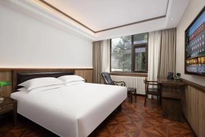 Postel nebo postele na pokoji v ubytování Nost algia Hotel Near Beijing Panjiayuan Antique Market- Beijing Happy Valley, CBD, China Zun and Sanlitun, Tian'anmen Square, Free ice cream, mineral water, coffee, snacks and laundry service, Free gymnastic, English communication well