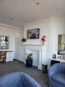 a living room with a fireplace with a picture on the wall at Atlantic Seafront in Brighton & Hove