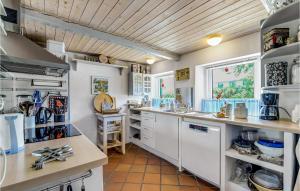 a kitchen with white cabinets and a wooden ceiling at Two-Bedroom Holiday Home In Haderslev in Haderslev
