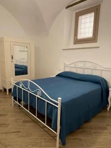 a bedroom with a bed with a blue blanket at A casa di nonna in Fondi