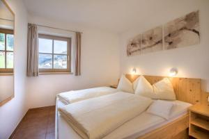 a bedroom with a large white bed in it at Schöneben Zwillinger Hütte in Wald im Pinzgau +25 photos