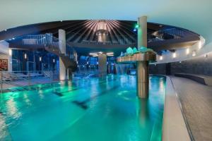 a swimming pool in a building with a water slide at Schöneben Zwillinger Hütte in Wald im Pinzgau