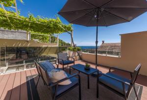 eine Terrasse mit Tisch, Stühlen und Sonnenschirm in der Unterkunft Hillside Apartments in Dubrovnik + 39 Fotos