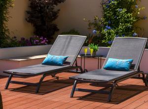 2 Stühle mit blauen Kissen auf einer Terrasse in der Unterkunft Hillside Apartments in Dubrovnik
