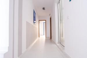an empty hallway with white walls and a window at Mellieha, Charming 2 Bedroom Apartment Santa Maria Heights Mellieha in Mellieħa