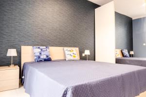 a bedroom with a large bed with blue sheets at Mellieha, Charming 2 Bedroom Apartment Santa Maria Heights Mellieha in Mellieħa +5 photos