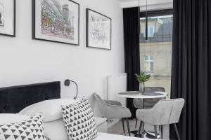 a room with a table and chairs and a window at Selenite - Studio with Balcony & AC - City Center in Krakow