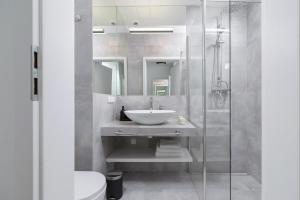 a bathroom with a sink and a shower at Selenite - Studio with Balcony & AC - City Center in Krakow
