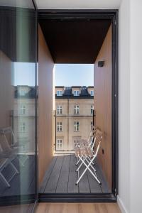 a chair on a balcony with a view of a building at Selenite - Studio with Balcony & AC - City Center in Krakow