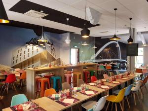 a dining room with long tables and chairs at Brit Hotel Lyon Nord Dardilly in Dardilly
