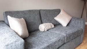 a gray couch with two pillows and a stuffed animal on it at Beauly House in Falkirk +43 photos