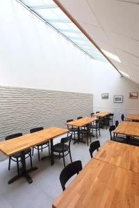 a room with wooden tables and chairs and a brick wall at Brit Hotel Calais in Calais