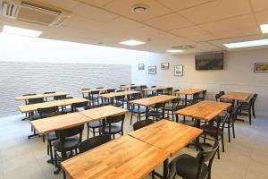 an empty classroom with wooden tables and chairs at Brit Hotel Calais in Calais