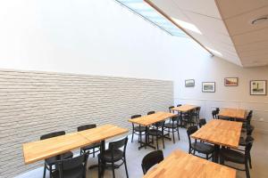 a row of tables and chairs in a room with a brick wall at Brit Hotel Calais in Calais