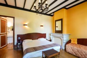 a bedroom with a large bed and a fireplace at Brit Hotel Notre Dame in Valenciennes