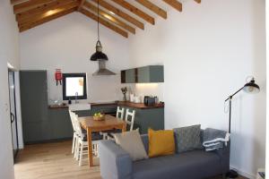 a living room with a couch and a table and a kitchen at Casa da Vila in Velas