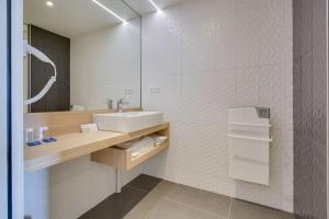 un baño con lavabo y espejo en Brit Hotel Confort Saint-Dizier, en Saint-Dizier
