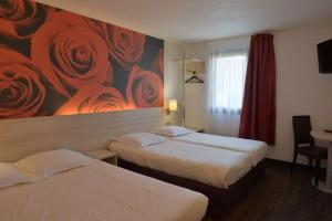 two beds in a hotel room with a painting of roses at Brit Hotel Essentiel de Granville in Granville