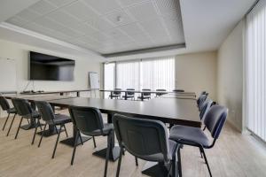 a conference room with a large table and chairs at Brit Hotel Confort Saint-Dizier in Saint-Dizier