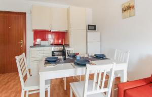 a kitchen with a white table with chairs and a stove at Pet Friendly Apartment In Torremolinos in Torremolinos