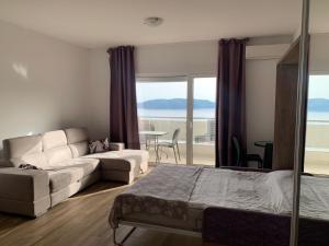 un soggiorno con un letto e un divano di Apartments GC 3 a Rafailovici