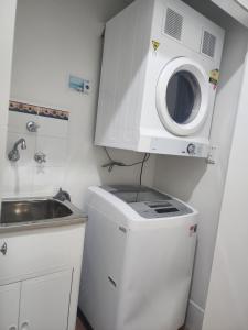 曼哲拉Apartment in Apollo Quays resort with shared Jetty的小厨房配有洗衣机和水槽