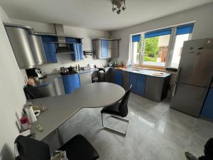 a kitchen with blue cabinets and a table with chairs at Noclegi Gródek nad Dunajcem in Gródek Nad Dunajcem +14 photos