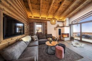 a living room with a couch and a fireplace at Nationalpark Chalet Schneespitze in Neukirchen am Großvenediger