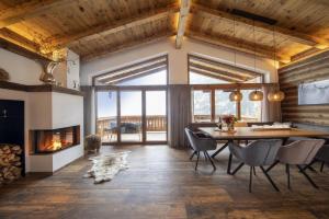 a dining room with a fireplace and a table and chairs at Nationalpark Chalet Schneespitze in Neukirchen am Großvenediger