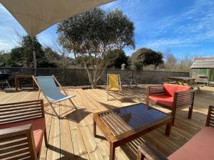 a wooden deck with chairs and a table and a bench at Maison 10 lits proximité du Port - YEU Ker Chalon in Port-Joinville