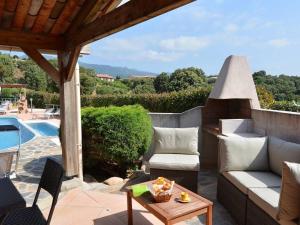 a patio with a couch and a table and a pool at Domaine San Sebastiano in Porto-Vecchio