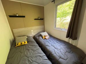 a bedroom with two beds and a window at Camping de Collonges-la-Rouge in Meyssac +34 photos