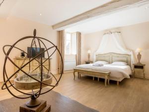 a bedroom with a large bed and a table at Le Cara in Beaune