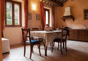 a dining room with a table with chairs and a kitchen at Le Residenze degli Ulivi in Campofilone