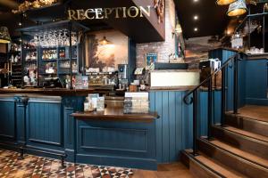 a bar in a restaurant with blue walls at The Waterhead Inn, Ambleside- The Inn Collection Group in Ambleside