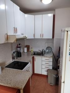 a kitchen with white cabinets and a sink at Parovic in Nevesinje