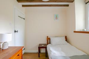 een slaapkamer met een bed en een tafel met een lamp bij Grade II Old Engine House, on the SW Coast Path in Noss Mayo