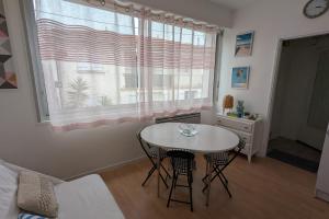 Una sala de estar con una mesa y una ventana. en Cozy 24 m studio near the sea, en La Tranche-sur-Mer