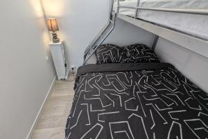 Un dormitorio con una litera con ropa de cama en blanco y negro. en Cozy 24 m studio near the sea, en La Tranche-sur-Mer
