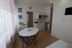 cocina con mesa blanca y sillas en una habitación en Cozy 24 m studio near the sea, en La Tranche-sur-Mer 2 fotos más