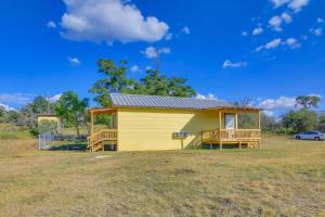a small yellow house with a porch on a field at Ranch Cabin with Decks, 10 Mi to Fredericksburg in Fredericksburg