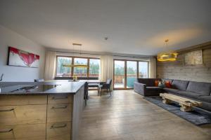 une cuisine et un salon avec un canapé et une table dans l'établissement Nationalpark Chalet Grosser Happ, à Neukirchen am Großvenediger
