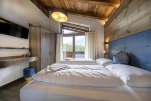 - 2 lits dans une chambre avec une grande fenêtre dans l'établissement Nationalpark Chalet Grosser Happ, à Neukirchen am Großvenediger